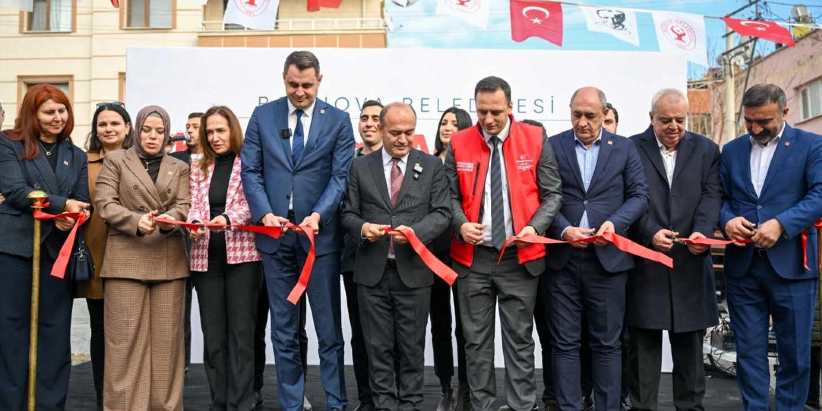 Bornova Belediyesi yetkililerinin ve davetlilerin, üzerinde Bornova Belediyesi yazılı bir pankartın önünde kırmızı kurdeleyi keserek gerçekleştirdiği resmi açılış töreni.