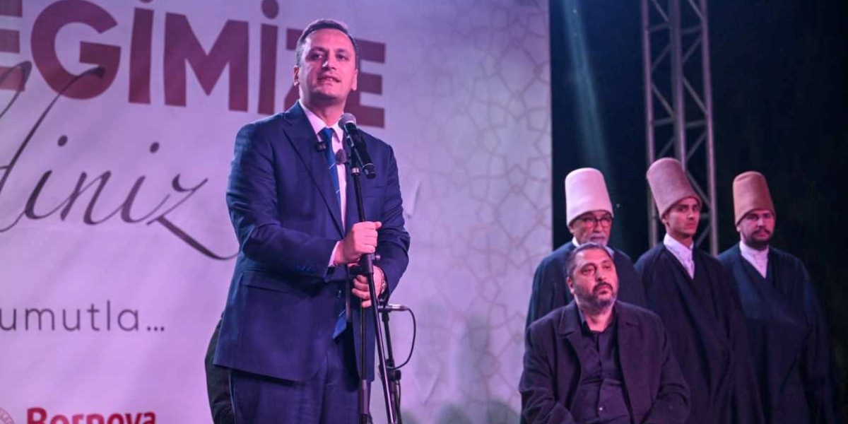 Koyu mavi takım elbiseli ve kravatlı bir erkek, arkasında 