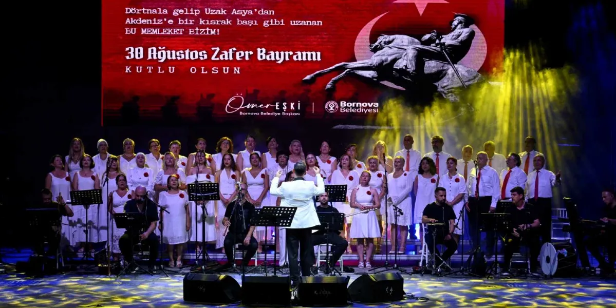 Beyaz kıyafetler giymiş kalabalık bir koro, sahne üzerinde bir şef yönetiminde konser veriyor. Koronun arkasındaki dev ekranda, üzerinde Nazım Hikmet’in 