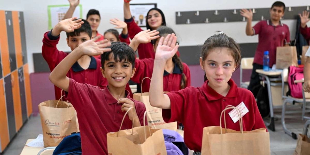 Okul üniforması olarak bordo polo yaka tişört giyen, önlerinde üzerinde 