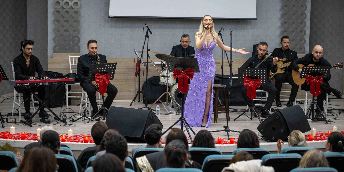 Sahne üzerinde, üzerinde işlemeler bulunan lila rengi uzun bir elbise giymiş kadın solist şarkı söylüyor. Soliste eşlik eden müzik grubu; klavye, saksafon, bateri, keman, bas gitar ve akustik gitar çalan altı erkek müzisyenden oluşuyor. Müzisyenlerin önündeki nota sehpaları kırmızı fiyonklarla süslenmiş. Sahnenin ön kısmı, izleyicilere bakan tarafta, kırmızı yapraklar ve yanan mumlarla dekore edilmiş. İzleyiciler, sahneye dönük şekilde oturmuş gösteriyi izliyor.