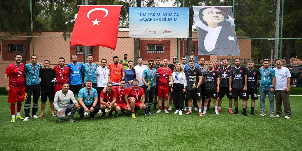 Halı sahada yan yana dizilmiş, boyunlarında madalyalar olan ve ellerinde kupalar tutan sporcu grubu. Arka planda asılı Türk bayrağı, Mustafa Kemal Atatürk posteri ve üzerinde 