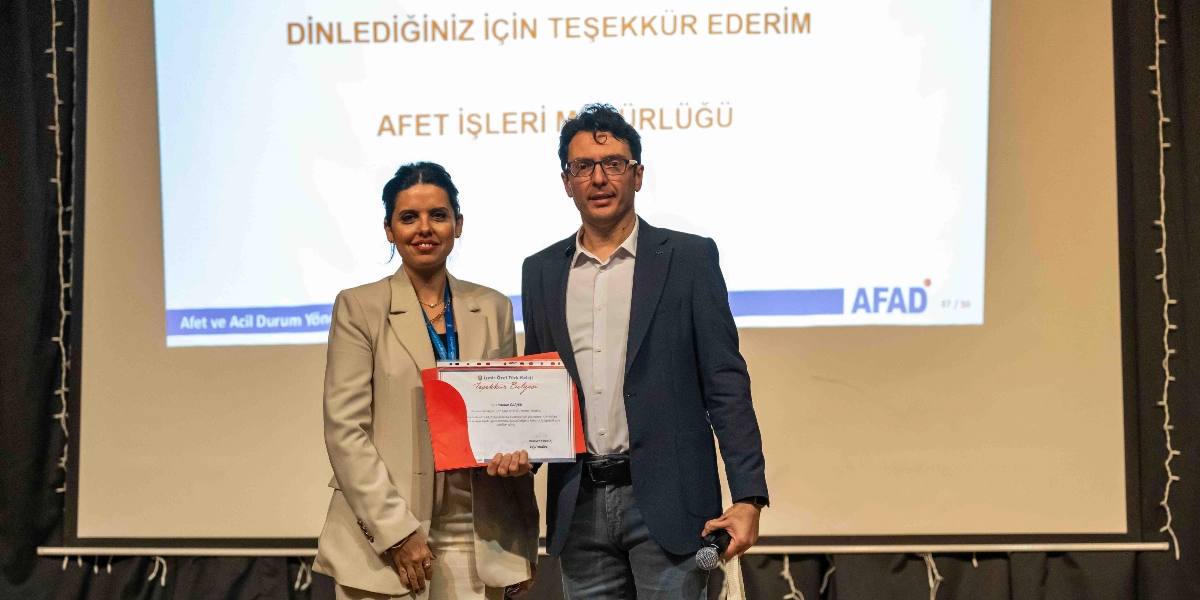 Bir kadın ve bir erkek, arkalarında 