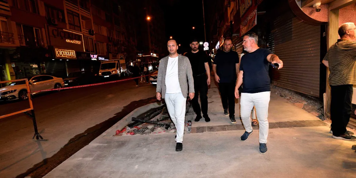 Gece vakti Bornova'da bir cadde üzerinde yürüyen, aralarında Bornova Belediye Başkanı Ömer Eşki'nin de bulunduğu bir grup yetkili, yenilenen kaldırım ve yol çalışmalarını inceleyerek ilerliyor.