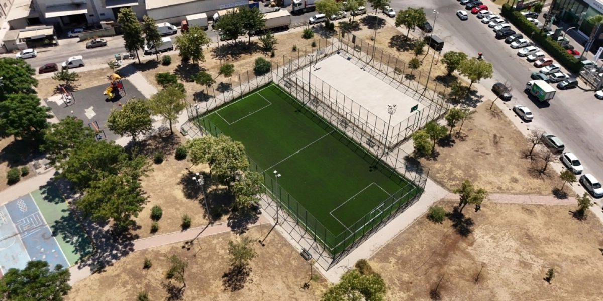 Bornova'da havadan çekilmiş bir spor tesisini gösteren görüntüde, yan yana konumlanmış suni çim kaplı bir futbol sahası ve beton zeminli bir basketbol sahası yer alıyor. Etrafı tellerle çevrili olan bu sahaların yakınında küçük bir çocuk oyun parkı, seksek çizgileri çizilmiş bir alan, ağaçlar ve toprak zeminli bir park alanı bulunuyor. Sahaların hemen yanında ise araçların park edildiği asfalt bir yol uzanıyor.
