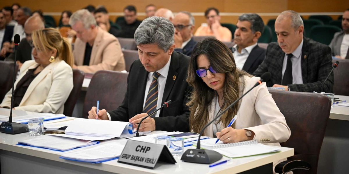 Bornova Belediyesi meclis toplantısında, ön sırada oturan ve önlerinde 