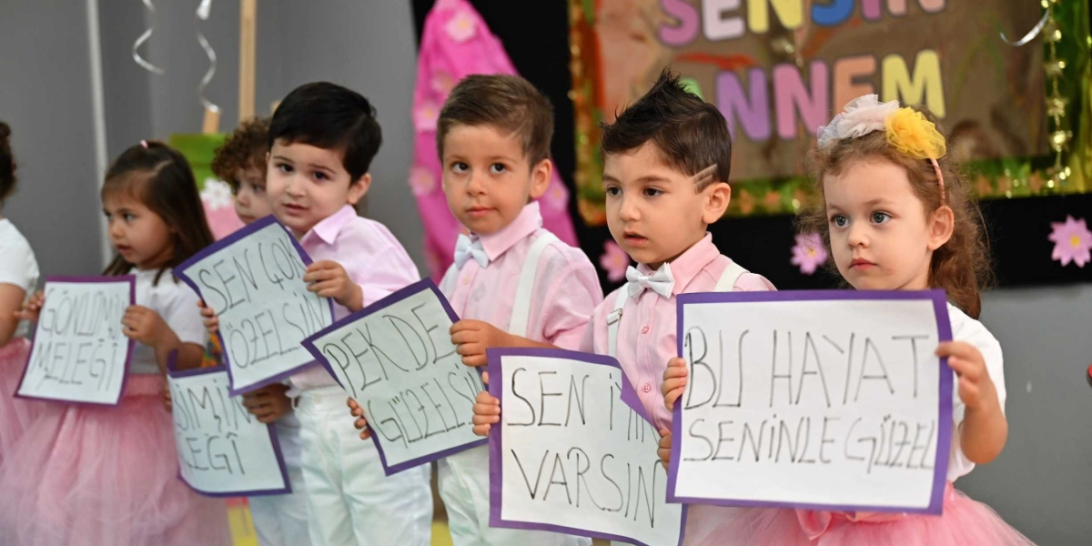 Anneler Günü kutlaması kapsamında yan yana dizilmiş, ellerinde üzerinde 