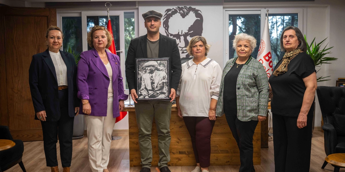 İç mekanda, arka planda Mustafa Kemal Atatürk’ün silüetinin yer aldığı bir odada yan yana duran altı kişilik bir grup. Grubun merkezinde, başında kasketiyle duran bir erkek, elinde Atatürk’ün şapkalı bir fotoğrafının bulunduğu çerçeveli bir tabloyu tutuyor. Grubun geri kalanını oluşturan beş kadın, şık kıyafetleriyle yan yana dizilmiş şekilde objektife bakıyor. Arka planda bir Türk bayrağı ve üzerinde 