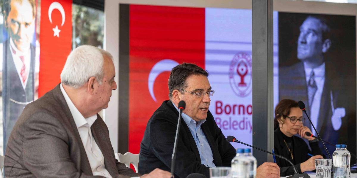 CHP Genel Başkan Yardımcısı Yankı Bağcıoğlu, Bornova Belediyesi'nde düzenlenen bir toplantıda konuşma yapıyor. Masada Bağcıoğlu'nun yanında bir erkek ve bir kadın katılımcı yer alıyor. Arka planda Türk bayrağı, Mustafa Kemal Atatürk'ün portreleri ve Bornova Belediyesi logosunun yer aldığı dijital bir ekran bulunuyor.