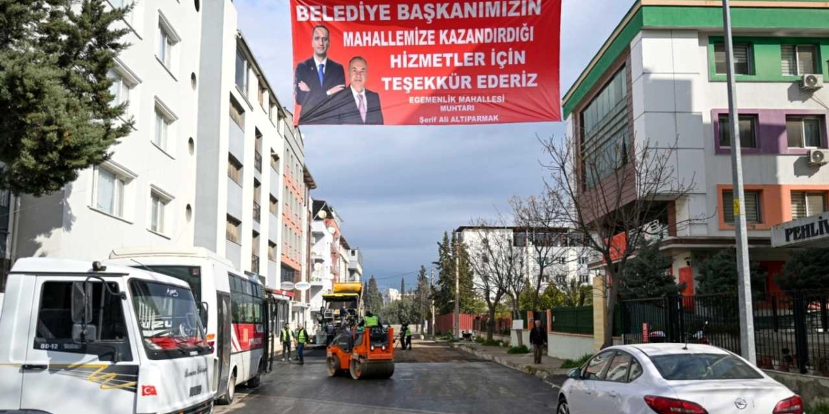 İki bina arasına asılmış, üzerinde iki kişinin fotoğrafının ve 