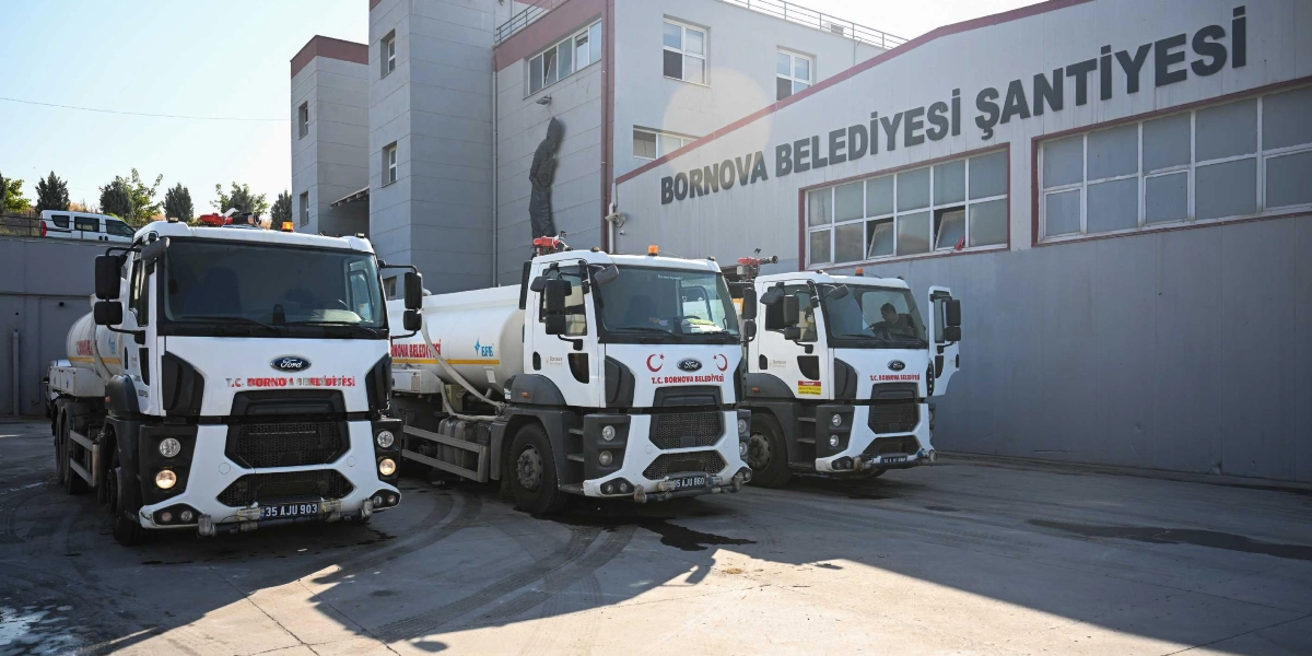 Bornova Belediyesi Şantiyesi binasının önünde yan yana park etmiş, üzerinde T.C. Bornova Belediyesi yazılı üç adet beyaz Ford marka tanker kamyon.