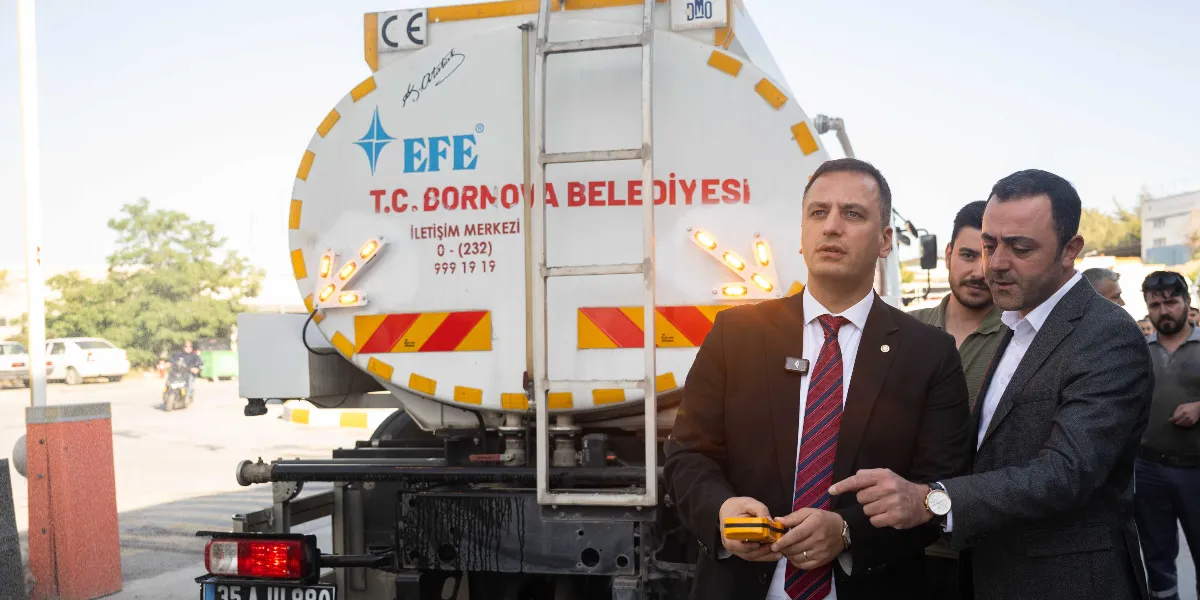 Üzerinde T.C. Bornova Belediyesi yazılı beyaz bir su tankerinin önünde, takım elbiseli iki erkek yetkili elindeki cihazı inceleyerek konuşuyor. Tankerin üzerinde EFE markası, iletişim merkezi numarası ve Mustafa Kemal Atatürk'ün imzası yer alıyor.