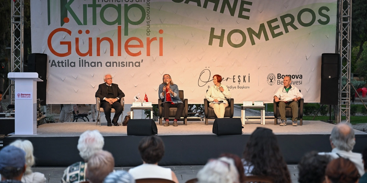 Bornova Belediyesi tarafından düzenlenen Homeros Kitap Günleri etkinliğinde, sahnede dört konuşmacı oturarak bir söyleşi gerçekleştiriyor. Arka planda üzerinde 