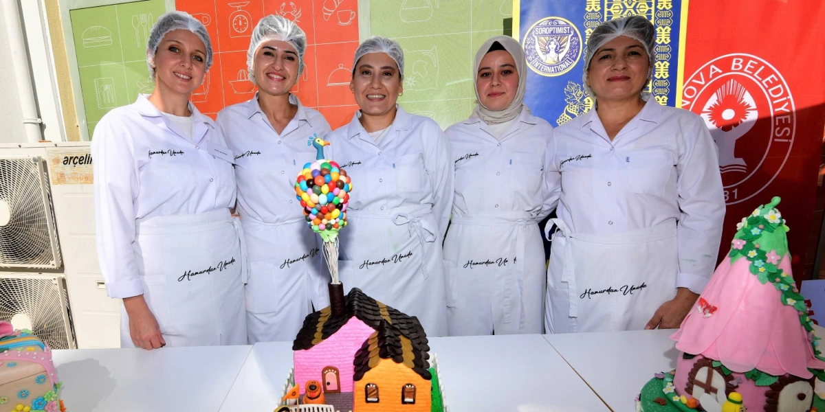 Beyaz önlük ve bone giymiş beş kadın, önlerinde hazırladıkları pastalarla yan yana durarak gülümsüyor. Kadınların önlüklerinin üzerinde 