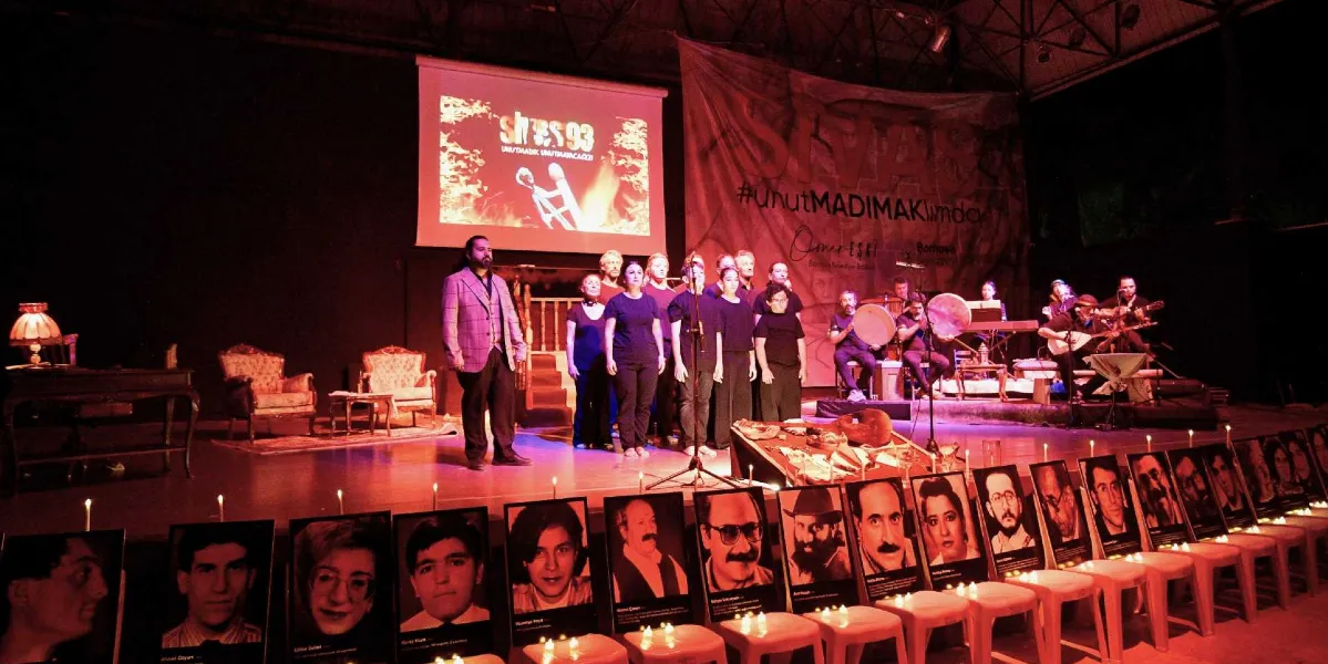 Sivas Katliamı'nı anma etkinliğinde, sahnenin ön kısmında beyaz tabureler üzerine dizilmiş, hayatını kaybedenlerin siyah beyaz fotoğrafları ve önlerinde yanan mumlar yer alıyor. Sahnenin arka planında 