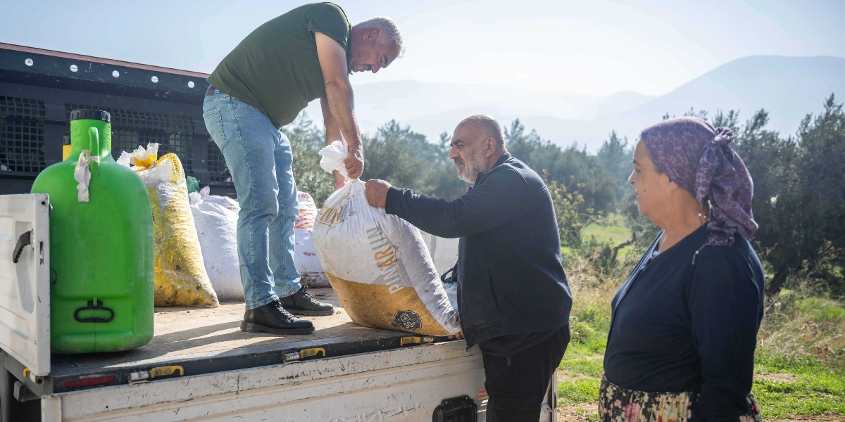 Açık havada, bir kamyonetin kasasında iki erkek, üzerinde 