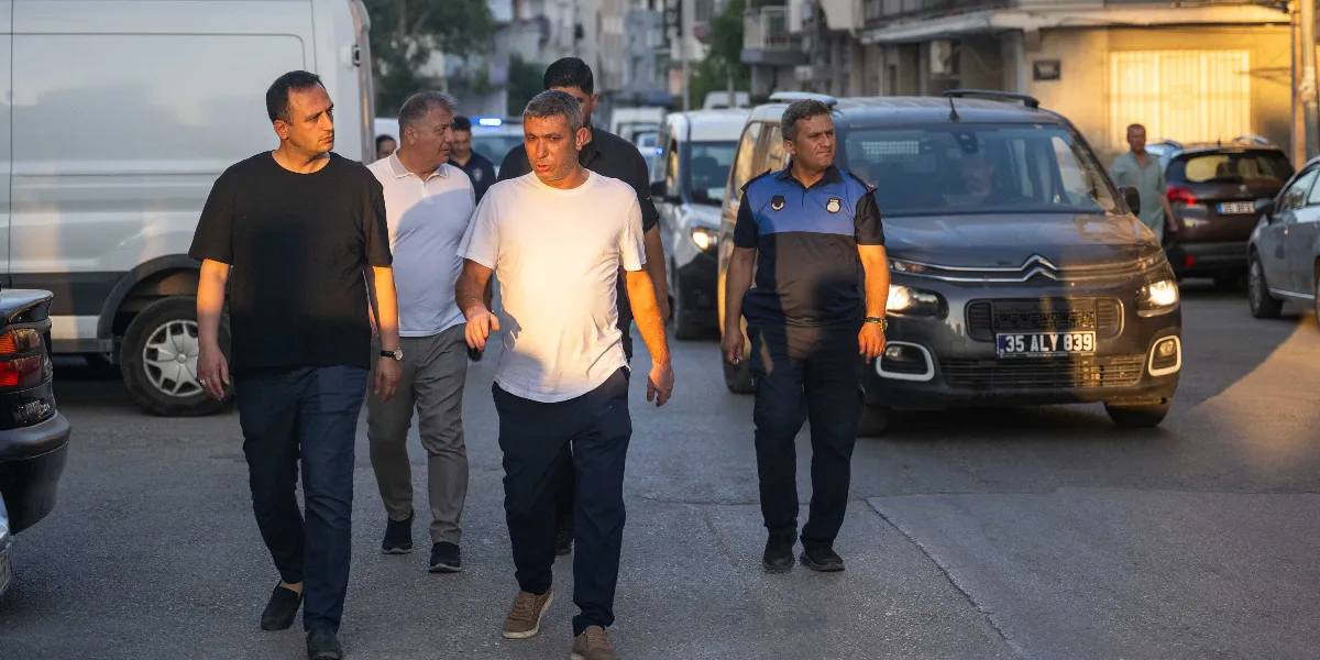 Belediye başkanı ve beraberindeki heyet, zabıta memuru eşliğinde sokakta yürüyerek denetim gerçekleştiriyor.