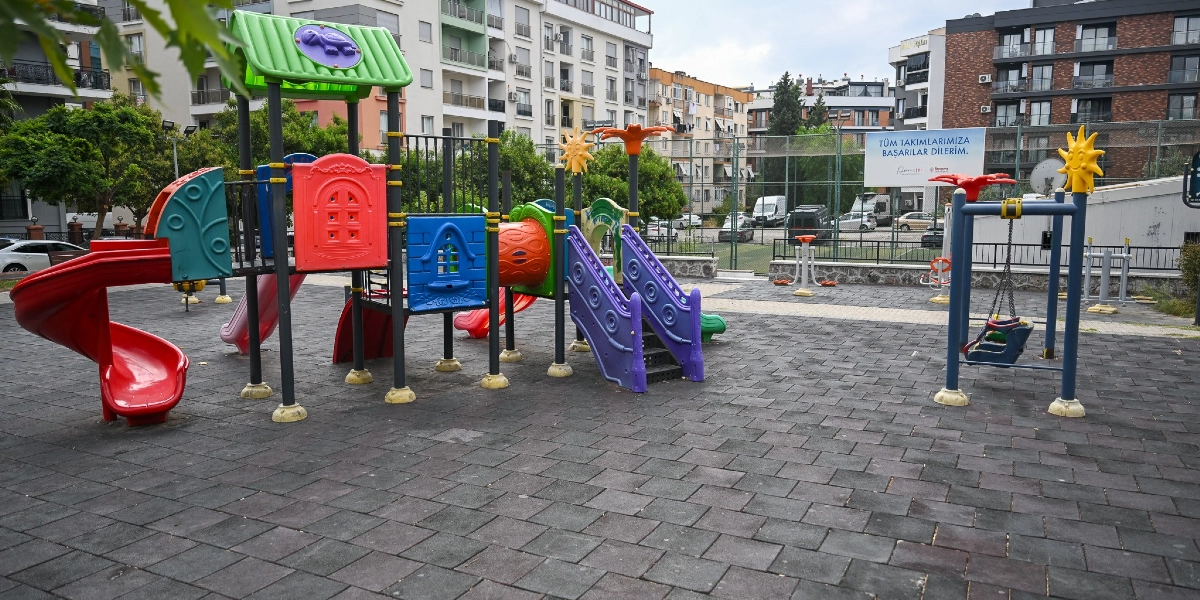 Bornova'da yerleşim yerleri arasında bulunan, zemininde kauçuk kaplama olan bir çocuk parkı. Parkın merkezinde kırmızı, mavi ve yeşil renkli kaydıraklar, tırmanma bölümleri ve çatısında kaplumbağa figürü bulunan bir oyun grubu yer alıyor. Sağ tarafta güneş figürlü süslemelere sahip bir salıncak ve arka planda spor aletleri bulunuyor. Arka taraftaki çitlerin üzerinde 