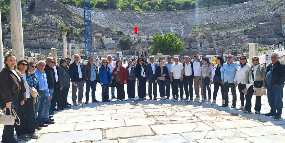 Efes Antik Kenti'ndeki büyük tiyatronun önünde yan yana durarak poz veren, Bornova Muhtarlar Akademisi katılımcısı olduğu anlaşılan kalabalık bir grup insan.