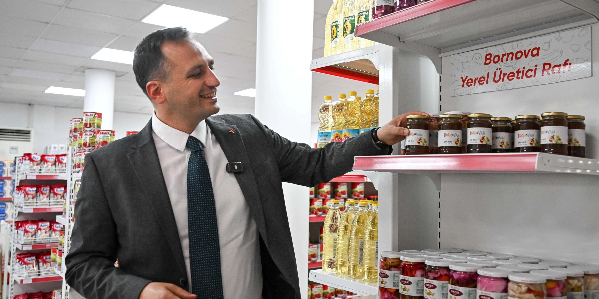 Koyu renk takım elbiseli ve kravatlı bir erkek, bir market reyonunda 