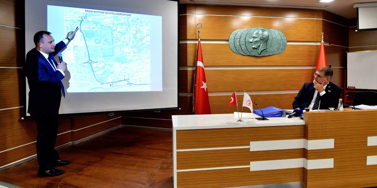 Takım elbiseli bir kişi, projeksiyon perdesine yansıtılan 