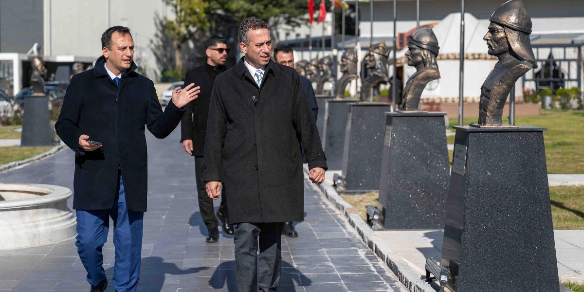 Ali Mahir Başarır ve beraberindeki heyet, Bornova'da bulunan ve üzerinde tarihi Türk büyüklerinin büstlerinin yer aldığı bir yürüyüş yolunda ilerleyerek sohbet ediyor.