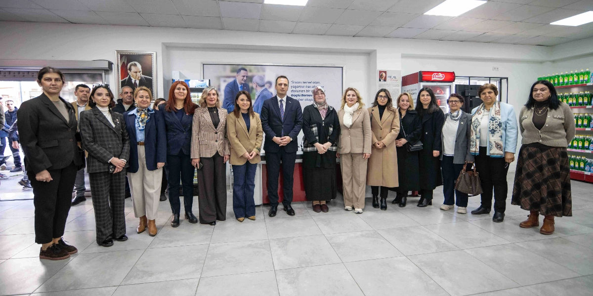 CHP Kadın Kolları Başkanı Asu Kaya ve beraberindeki heyet, Bornova Belediye Başkanı Ömer Eşki ile birlikte bir sosyal market içerisinde yan yana durarak poz veriyor. Arka planda Mustafa Kemal Atatürk'ün portresi ve üzerinde 