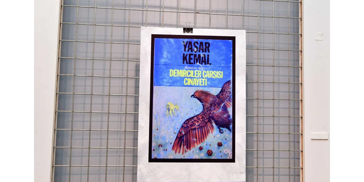 Metal bir ızgara pano üzerine mandalla asılmış, Yaşar Kemal'in Akçasazın Ağaları serisinin ilk kitabı olan 