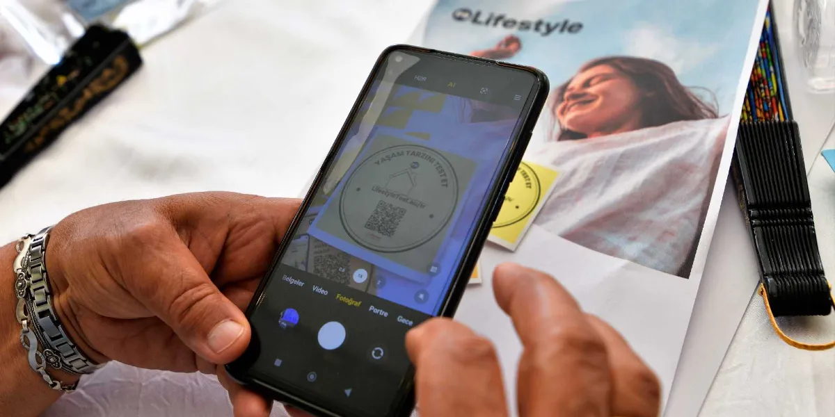 Bir kişinin elinde tuttuğu akıllı telefon, üzerinde 