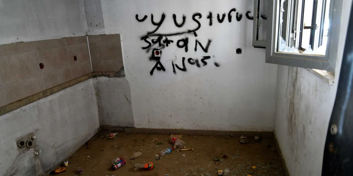 Terk edilmiş, kirli ve boş bir odanın beyaz duvarına siyah sprey boya ile 