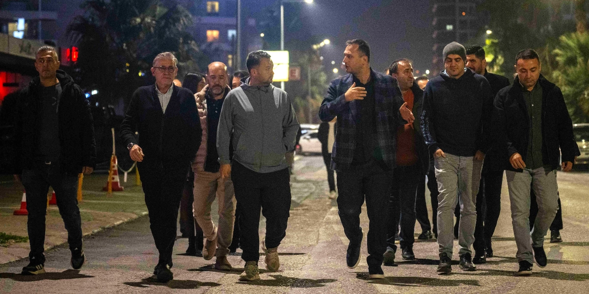 Gece vakti Bornova sokaklarında yürüyen, aralarında Bornova Belediye Başkanı Ömer Eşki'nin de bulunduğu bir grup erkek, bir konu üzerinde konuşarak ilerliyor. Gruptakiler günlük ve spor kıyafetler giymiş olup, çevredeki sokak lambalarının aydınlattığı yolda toplu halde yürüyorlar.