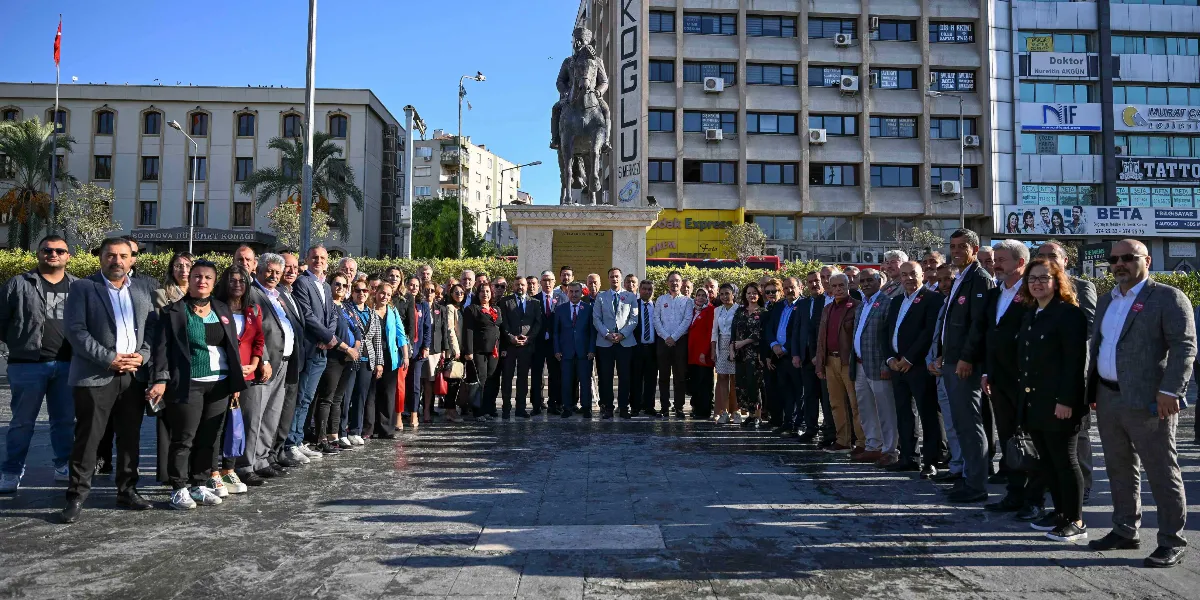 Bornova Hükümet Konağı önündeki meydanda, Atatürk heykeli etrafında toplanmış, resmi kıyafetli kalabalık bir grup muhtar ve yerel yetkili toplu fotoğraf çektiriyor.