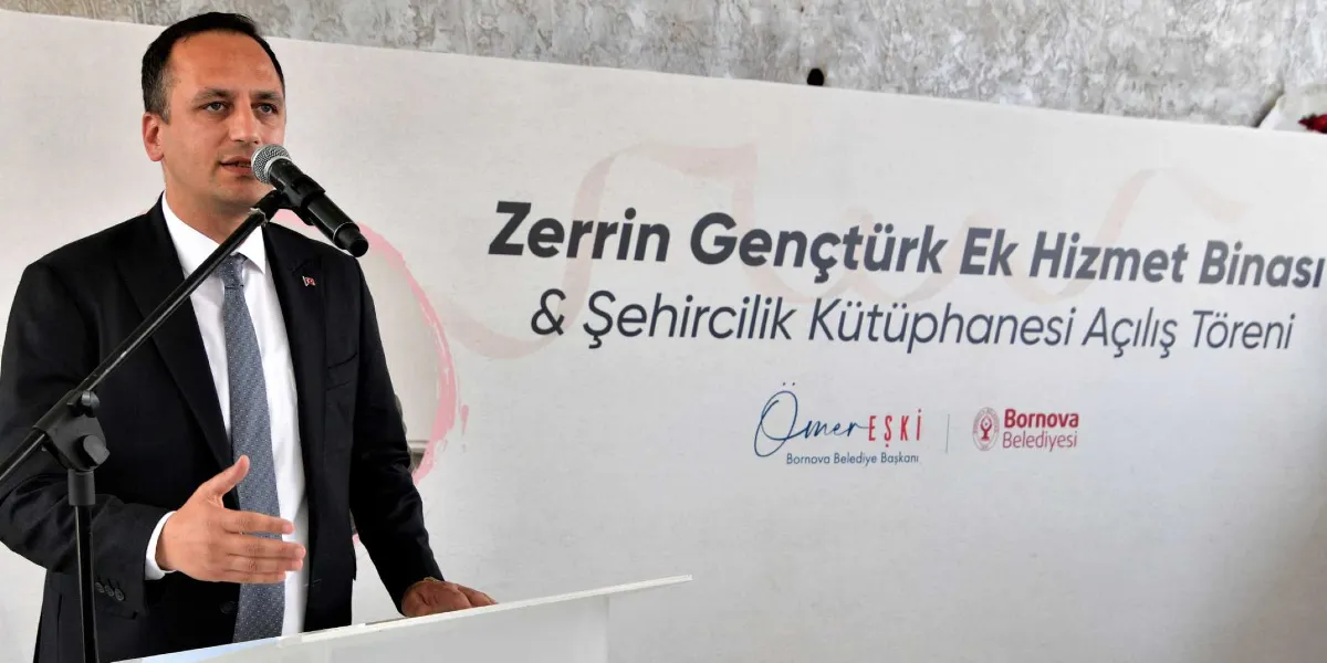Bornova Belediye Başkanı Ömer Eşki, kürsüde konuşma yaparken görülüyor. Arka planda üzerinde 