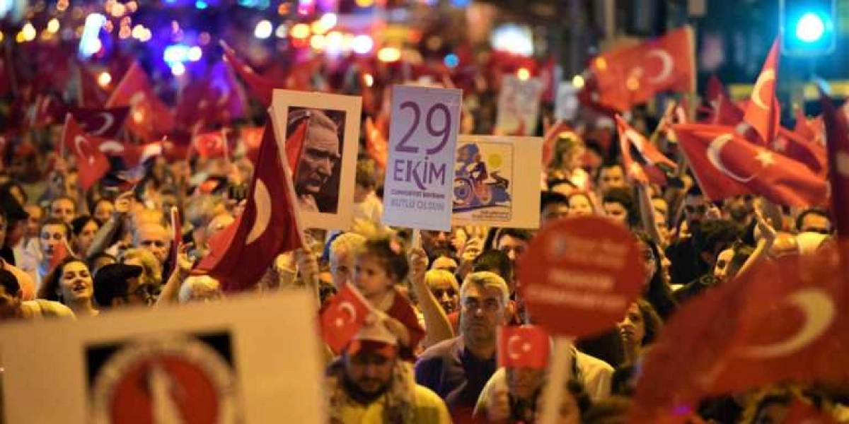 Gece vakti kalabalık bir caddede ellerinde Türk bayrakları ve üzerinde 
