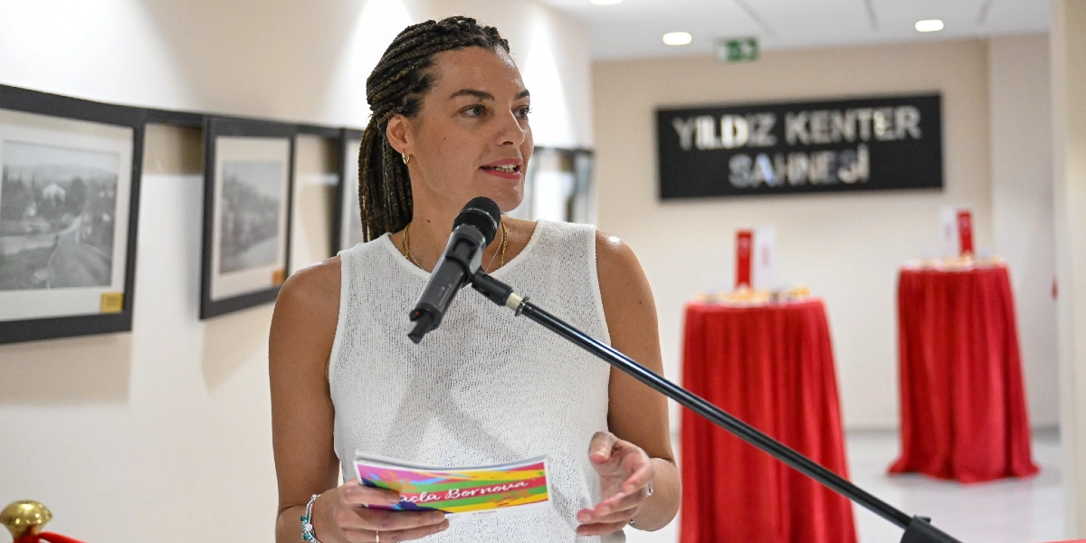 Örgülü saçlı bir kadın, Yıldız Kenter Sahnesi'nde elinde üzerinde 