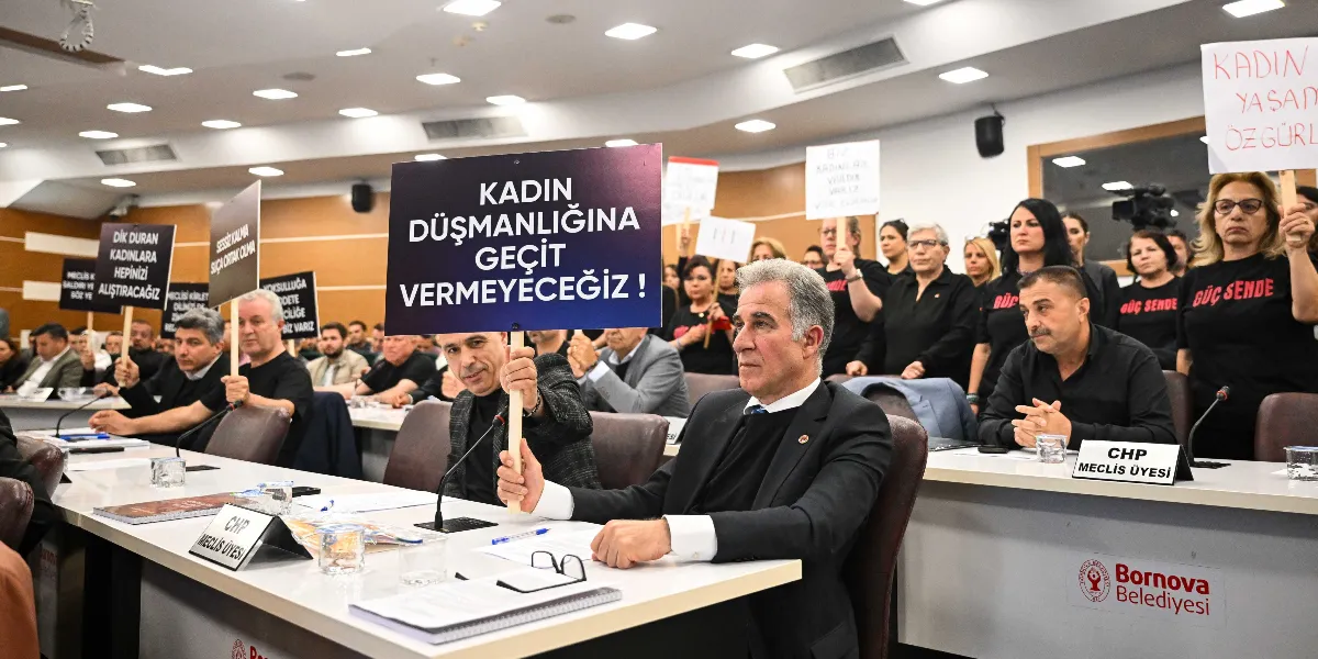 Bornova Belediyesi meclis salonunda düzenlenen bir toplantıda, katılımcılar ellerinde üzerinde 