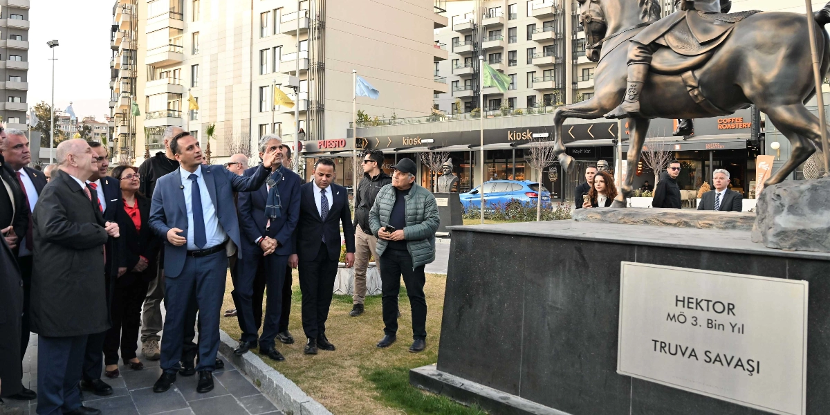 Ümit Özdağ ve beraberindeki bir grup, Abide-i Hürriyet Meydanı'nda bulunan Hektor atlı heykelini inceliyor. Özdağ, eliyle heykeli işaret ederek yanındakilere bir şeyler anlatıyor. Heykelin kaidesinde 