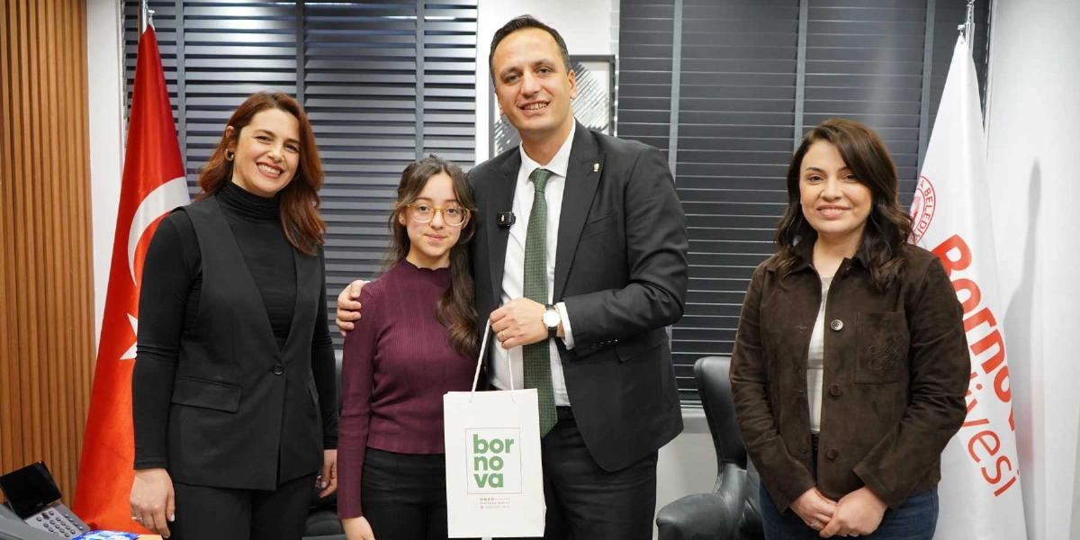 Bornova Belediye Başkanı, yanında iki kadınla birlikte başarılı bir öğrenciye üzerinde 