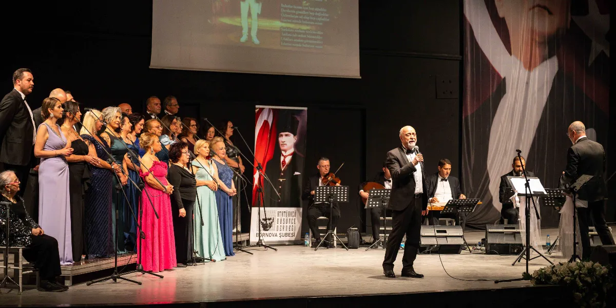 Sahne üzerinde, sol tarafta şık kıyafetler giymiş kalabalık bir koro, sağ tarafta ise bir orkestra eşliğinde şarkı söyleyen bir solist yer alıyor. Arka planda Atatürk'ün silüetinin bulunduğu büyük bir Türk bayrağı ve Atatürkçü Düşünce Derneği Bornova Şubesi'nin logosunun yer aldığı bir afiş bulunuyor. Sahnenin üst kısmındaki ekranda ise şarkı sözleri yansıtılıyor.