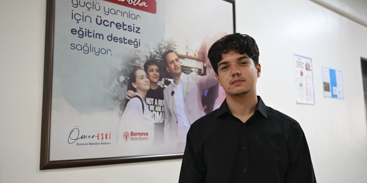 Siyah gömlekli genç bir erkek, duvarda asılı olan ve üzerinde 