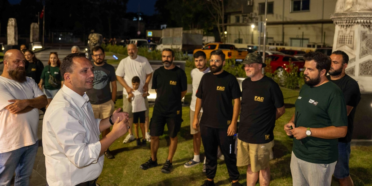 Bornova'da akşam saatlerinde bir araya gelen off-road tutkunu bir grup, açık havada sohbet ediyor. Grubun önünde beyaz gömlekli bir kişi konuşma yaparken, etrafında 